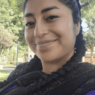 Marisol Rodríguez Jiménez smiling at the camera against a background of trees.